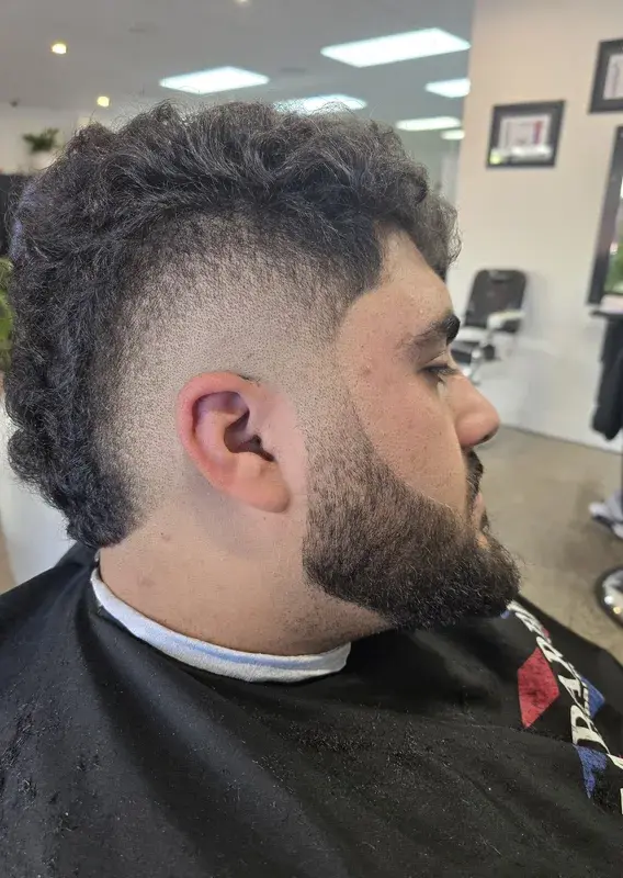Trainee barber attentively cutting a client's hair while an instructor supervises